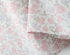 Dettaglio della stampa floreale francese con fiori rosa e viola su cotone bianco