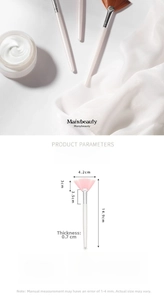 Detailed view of pink fan mask brush with nylon bristles and silver aluminum ferrule