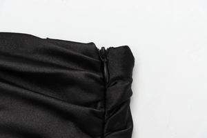 Detailed close-up of an invisible zipper on black pleated satin fabric for women's tops