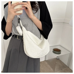 Detail of white textured crossbody bag with matching coin purse and adjustable strap