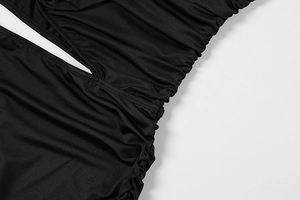 Close-up of ruched elastic fabric and cutout detail on a black sexy bodycon dress