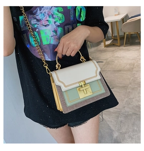 Detail of multi-color crossbody bag with golden chain strap and woven texture