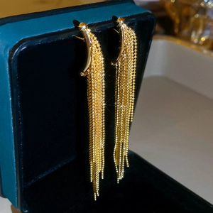 Detail of gold-plated waterdrop tassel earrings with shimmering multi-layer metal bead chains