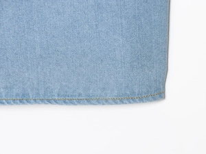 Detail der blauen Denim-Stoff mit gelben Kontrastnähten und Twill-Textur-Webart