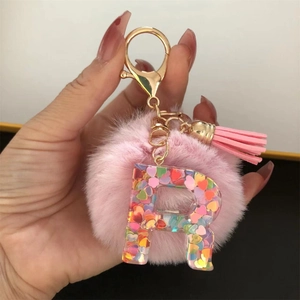 Pink faux fur pompom keychain with resin letter R and colorful heart sequins