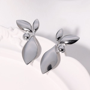 Polished silver leaf shaped titanium steel stud earrings on a white embossed plate