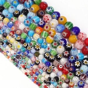 Colorful Millefiori glass beads in various sizes arranged diagonally on white background