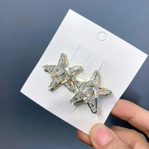Macro detail of star-shaped hair clips with sparkling crystals and gold plating