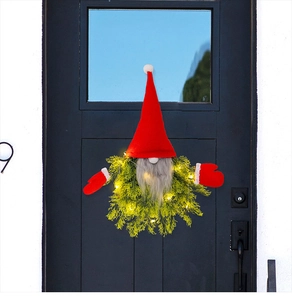 Close-up of glowing Christmas gnome wreath with warm LED lights on a black wooden door