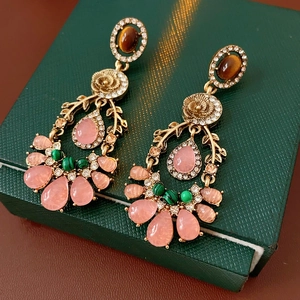 Dettaglio di orecchini vintage a fiore con strass e pietre di cristallo multicolore
