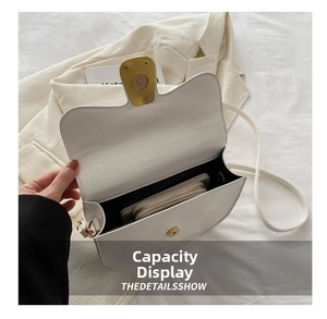 Interior view of white leather saddle bag showing large capacity and magnetic buckle
