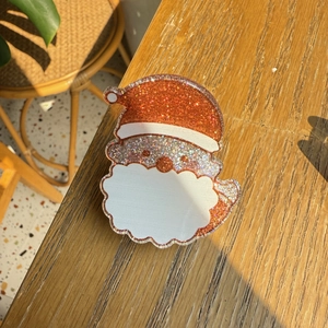Sparkly Santa Claus hair accessory with glitter resin on a sunny wooden background