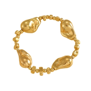 Détail d'un bracelet élastique doré avec des perles de lave irrégulières au lustre métal