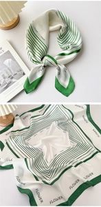 Detail of green and white silk scarf with geometric stripes and FLOWER print text