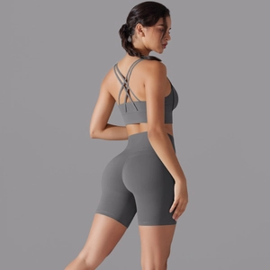Dettaglio del reggiseno yoga incrociato e pantaloncini sportivi grigi a vita alta