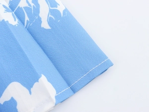Detail des blauen Blumenkleid-Stoffs mit hochwertigen Nähten und Textur