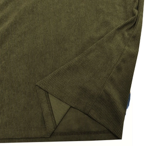 Detailed close-up of olive green corduroy fabric with sharp texture and stitching