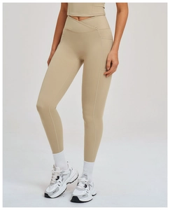 Détail d'un pantalon de yoga taille haute avec taille croisée en V et poches en beige