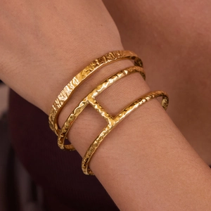 Macro view of golden 18K gold plated stainless steel bracelet with hammered texture detail