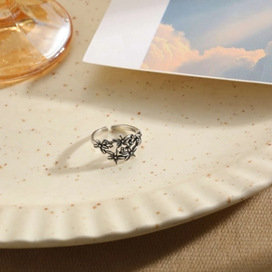 Vintage S925 sterling silver open ring with flower and leaf design on ceramic tray