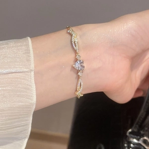 Elegant heart zircon bracelet with gold twisted chain shown on a woman wrist