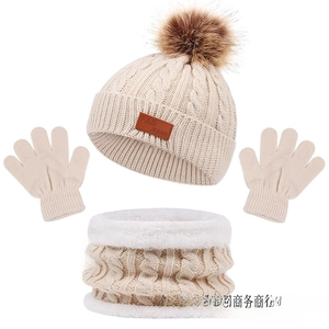 Detailed view of kids knit winter set featuring cream hat with pompom and fleece lining