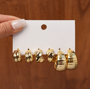 Detail of 6-piece golden geometric C-shaped hoop earrings set with textured metal finish