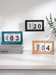 Detailed view of wooden perpetual flip calendars in black, teal, and natural wood finishes