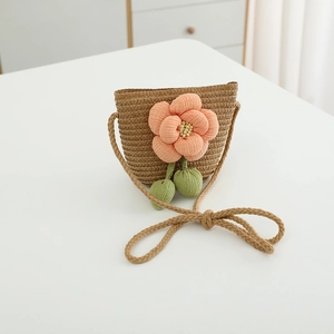 Detail der gewebten Strohtasche für Mädchen mit rosa Stoffblume und Perlenverzierung