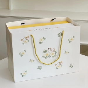 Elegant gift bag with Camellia and cat illustration featuring golden woven rope handles
