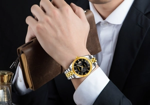 Detail of luxury business watch with date display and luminous hands on male wrist