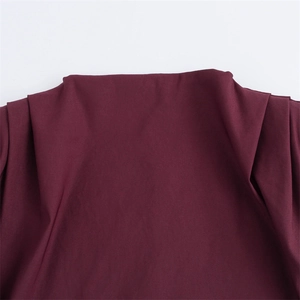 Détail du haut sans manches bordeaux avec plis à l'épaule et texture du tissu tissé