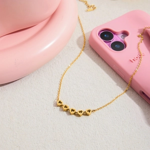 Detail of 18K gold stainless steel necklace with five heart-shaped zircon pendants