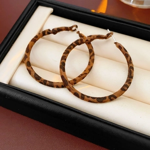 Close-up of leopard print hoop earrings in a black gift box showing velvet texture