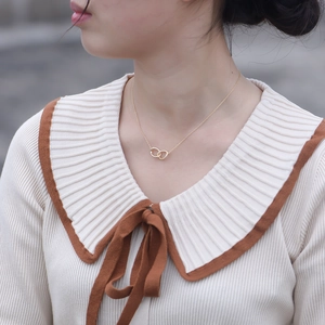 Collana in argento S925 con doppio anello intrecciato dorato indossata da una modella