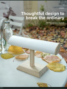 Detail view of T-bar jewelry stand with white leather cylinder and natural wooden base