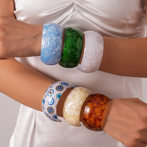 Acrylic geometric bangles featuring iridescent marble textures and evil eye prints