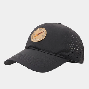 Macro detail of breathable laser-cut holes and compass patch on black baseball cap