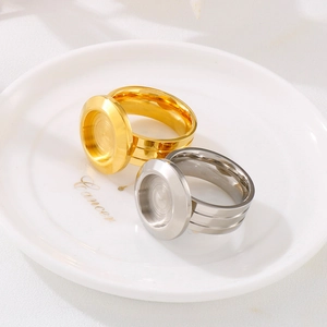 Bagues en acier inoxydable poli or et argent avec insert rond sur une assiette en céramique