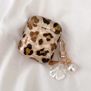 Détails de l'étui AirPods avec motif léopard, paillettes dorées et breloque en nacre