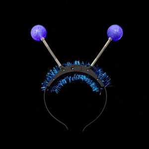Detail of blue tinsel antenna headband with spring glitter balls on black background