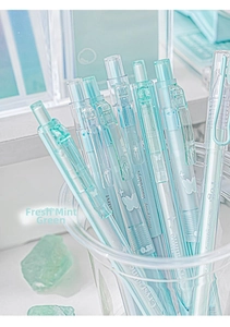 Macro view of mint green transparent gel pens with silver star and butterfly patterns