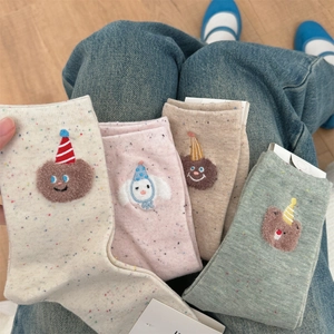 Detail of four pairs of cotton socks with bear embroidery and colorful speckles