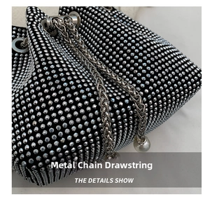 Detail of rhinestone bucket bag featuring metal chain drawstring and pearl pendant