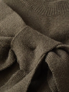Détail d'un haut en tricot vert olive montrant la texture côtelée et le nœud noué