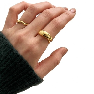 Polished gold cross geometric rings set with smooth and wavy bands on hand