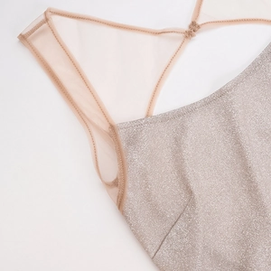 Détail de tissu pailleté champagne doré avec des bretelles en tulle rose semi-transparent