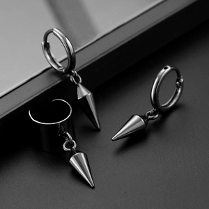 Detail of gun-black gothic earrings set with pointed cones and textured metal finish