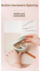 Detail of light green mini jewelry box with snap button and multi-grid storage layout