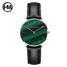 Detail of Hannah Martin watch featuring green malachite dial and black leather strap
